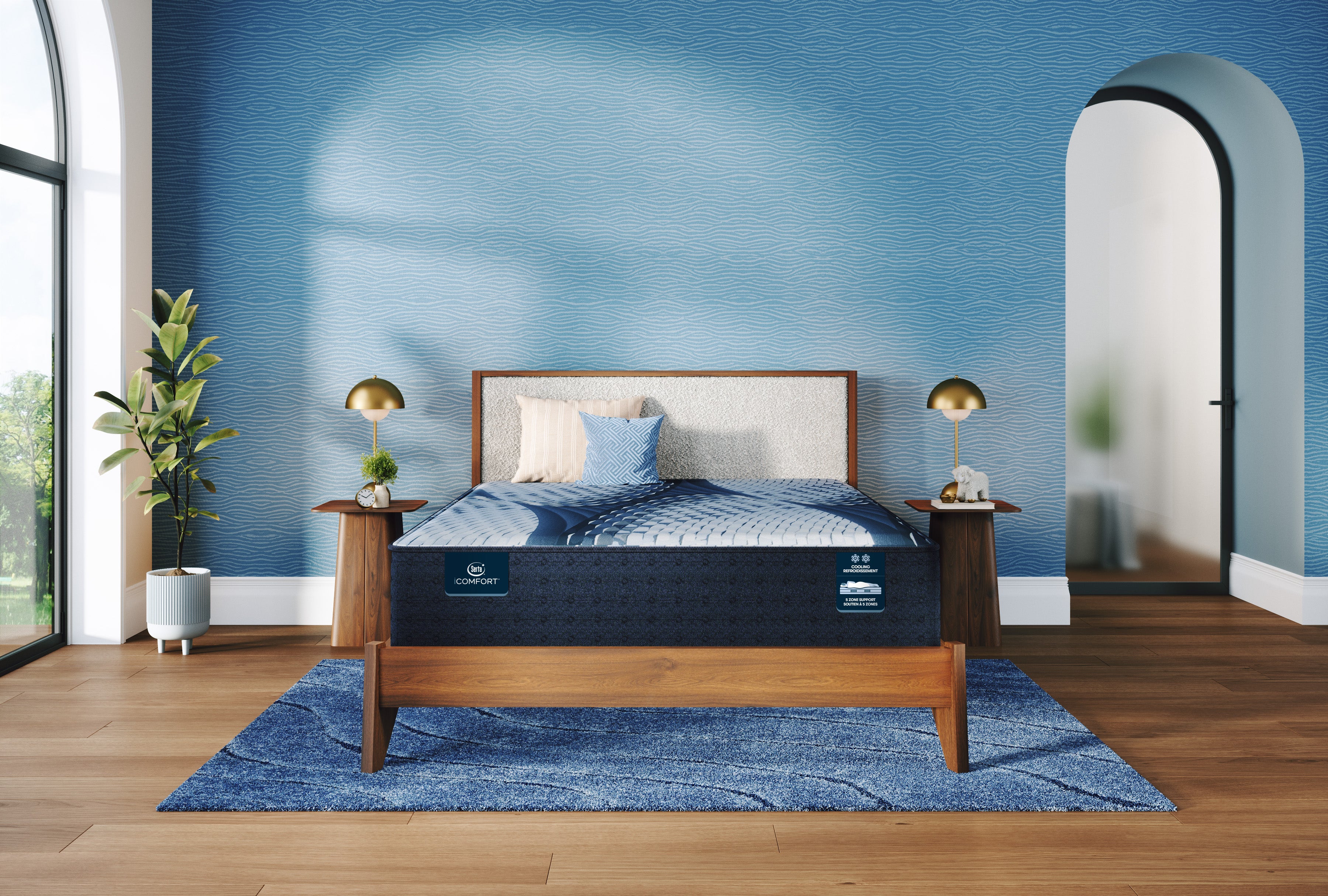 Bed with a blue mattress in a room with a blue wall and wooden floor.